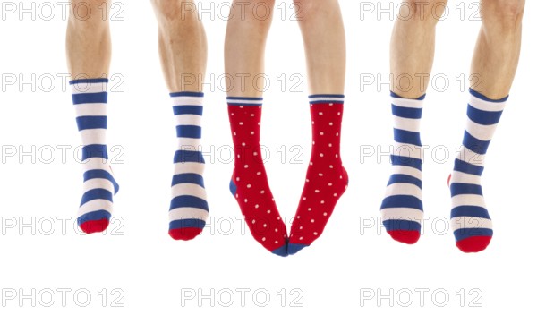 Feet in striped and dotted socks isolated over white background