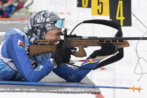 Sportswoman biathlete Arina Soldatova Kamchatka Krai rifle shooting prone position. Biathlete in shooting range. Open regional youth biathlon competitions East Cup. Kamchatka, Russia, Apr 12, 2019, Europe