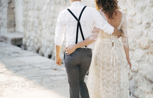 Bride and groom walk along the old pavements of the town. Bottom view.