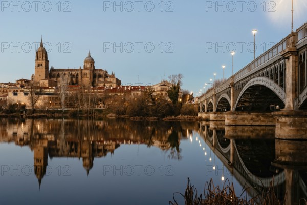 Scenic view of Salamanca with the Cathedral and iron bridge reflected in the Tormes River at sunset. Castilla Leon, Spain, Europe