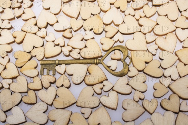 Retro style heart shaped key on wooden hearts