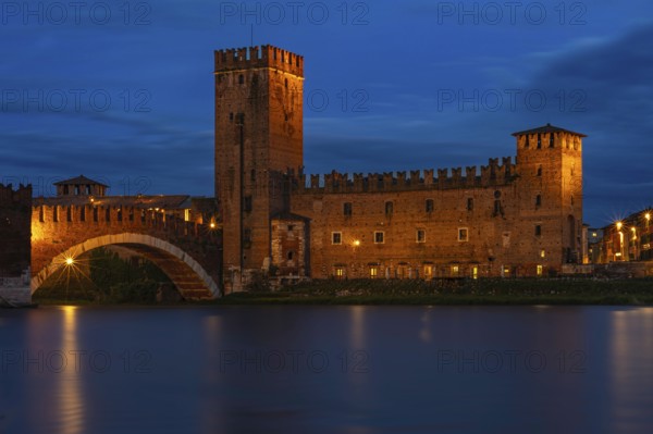 Majestic castle with bridge illuminated against the night sky with mirror-smooth river, at the blue hour, above the river Adige, Museo di Castelvecchio, Ponte Scaligero, Verona, Veneto region, Italy, Europe