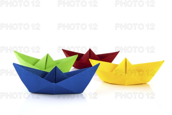 Colorful folded paper boats isolated over white background