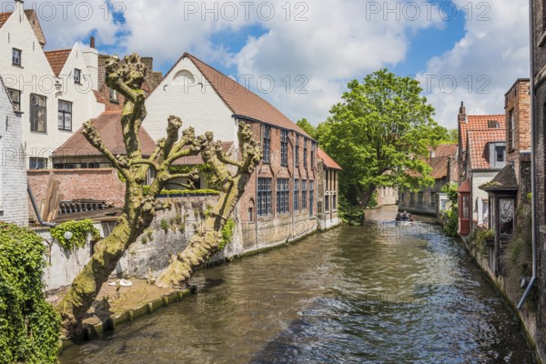 Boat full of tourist enjoying a beautiful canal in Bruges Belgium