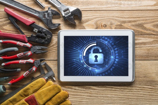 Tablet pc with security concept on screen and industrial tools around