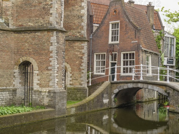 Historic brick building on a canal with small bridges and green surroundings, Delft, Netherlands