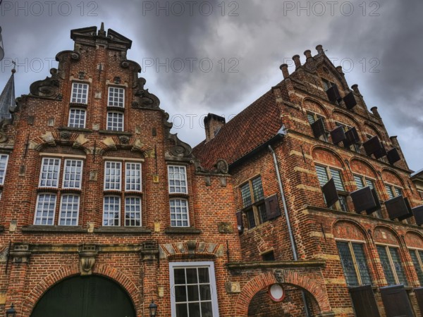 Historic brick houses with ornate facades, dramatic clouds in the sky, zutphen, gelderland, netherlands