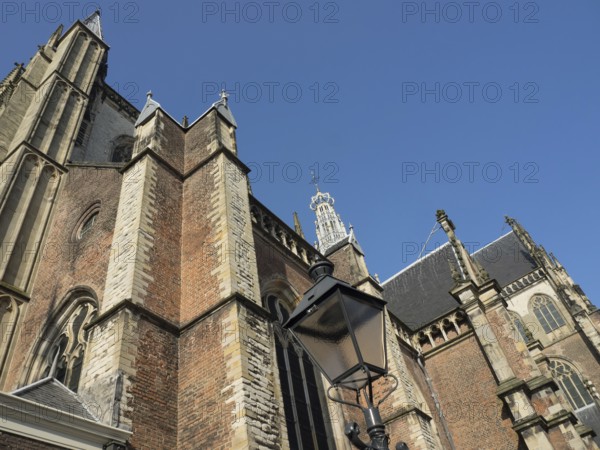 Large Gothic building with richly decorated towers and a black street lamp in front of it