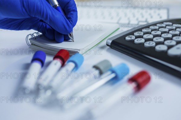 Close up photo of medicine bottles for samples next to computer tablet and computer keyboard in hospital or laboratory