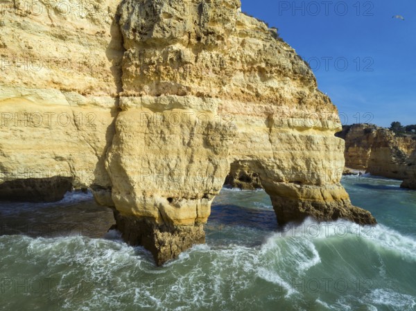 Aerial view on rock cliffs and waves near Praia da Marinha in the Algarve, Portugal, Europe