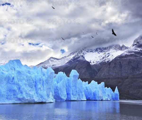 Journey to the End of the World. Chilean Patagonia in the clouds and sunshine. Blue Ice Glacier Gray is reflected in the lake