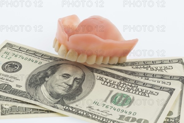 Dentures and dollar notes, symbol photo for dentures, treatment costs and co-payment