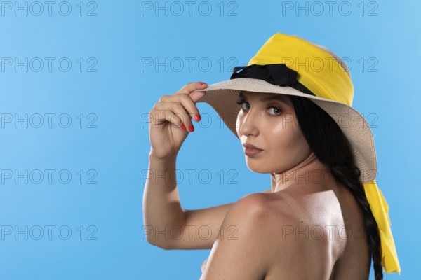 A teenager in a big beach hat holds a hand on a tanned shoulder