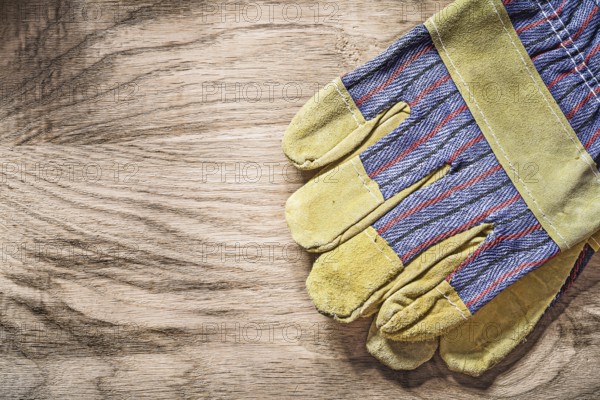 Protective gloves on wooden board construction concept