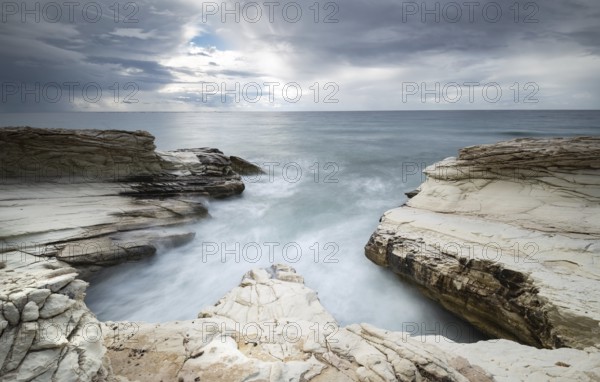 Beautiful Rocky coast with white limestones forming wonderful patterns and waves hitting the rocks. Long exposure photography