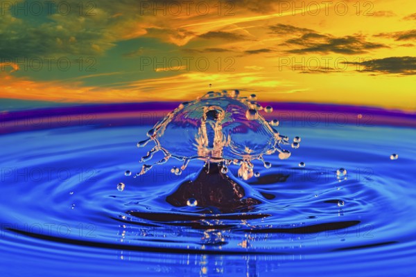A drop of water in the middle of a lake with a colourful sunset in the background, highspeed photography, drop photography, composing, Grenzach- Wyhlen, Baden-Württemberg, Germany, Europe