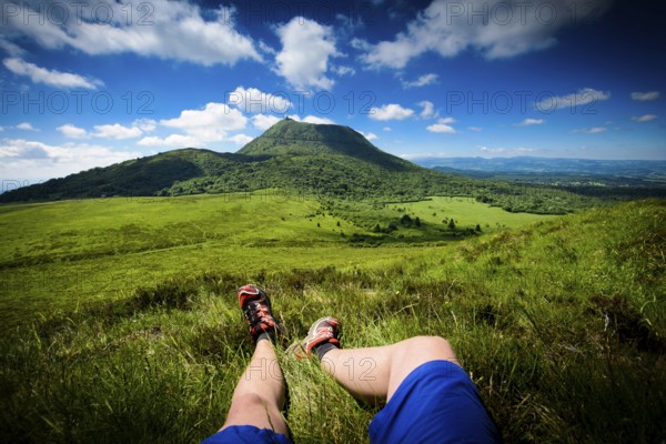 Puy de Dome mountain and hikers legs in Auvergne in France