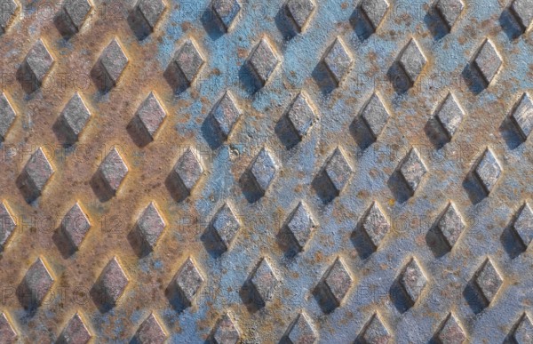 Old rusty drain cover background with diamond pattern
