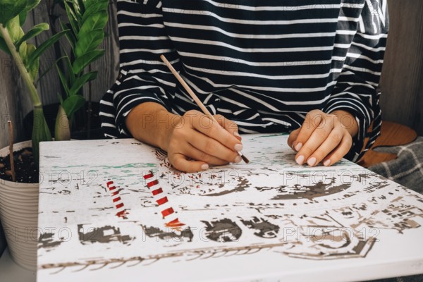 Female hands coloring canvas Picture by numbers Creative hobby. Painting for beginners. Leisure activity for stay home lockdown, anti-stress idea. Meditation, relax concept. Mindfulness acivity