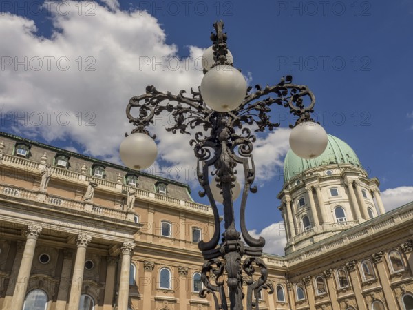 Historic lantern and building with green dome in Budapest under a cloudy sky, budapest, danube, hungary