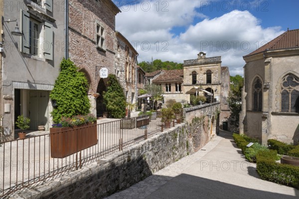 ThePlace Paul Froment with the Cafe des Arts and the Eglise de Marcandiel, corsten steel planter and town palace in one of the most beautiful villages in France, Penne-d'Agenais, Département Lot-et-Garonne, Region Nouvelle-Aquitaine, France, Europe