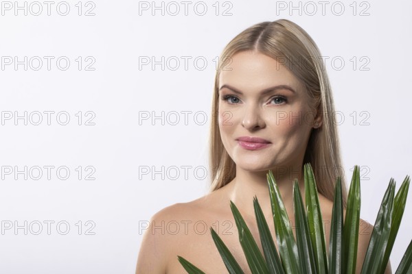 A woman elegantly poses with a lush aloe vera plant, showcasing the essence of natural beauty and holistic wellness