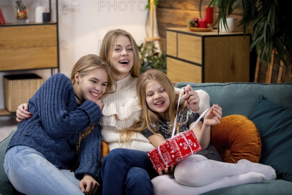 Three happy kids are joyfully sharing a playful moment on a cozy sofa, capturing the essence of friendship