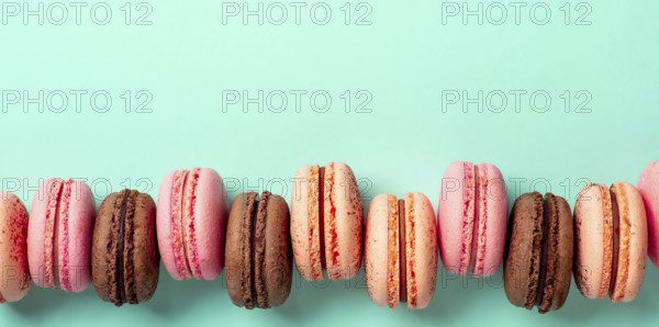 Macarons banner with copy space. Colorful french macarons or macaroons on blue turquoise background. Top view or flat lay