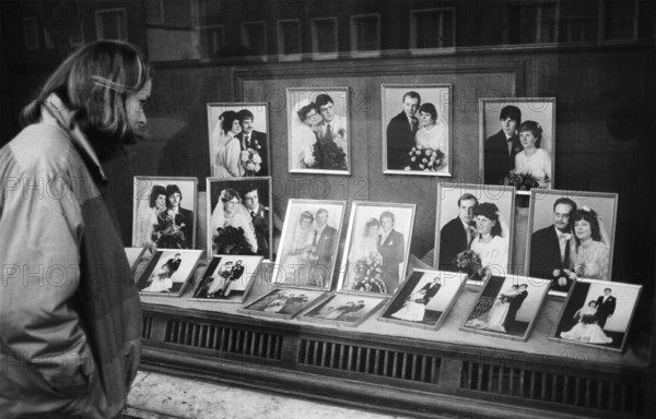 05/03/1983 GDR district of Cottbus town of Spremberg. Young woman looks into the shop window of the Kappelmüller photography business in Spremberg, which is decorated with photos of bridal couples. Studio