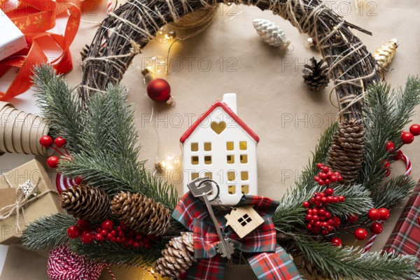 Key to the house with a keychain on a cozy home with a Christmas decor layout. A gift for New Year, Christmas. Building, design, project, moving to new house, mortgage, rent and purchase real estate