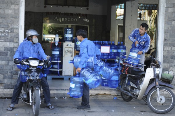 Vietnam/Saigon: Water supply by motorbike courier. water-supply with motorbike-taxi