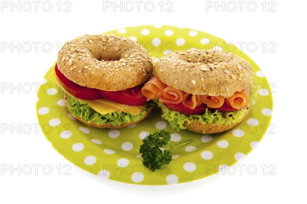 Fresh bagels with cheese, vegetables and fish isolated over white background