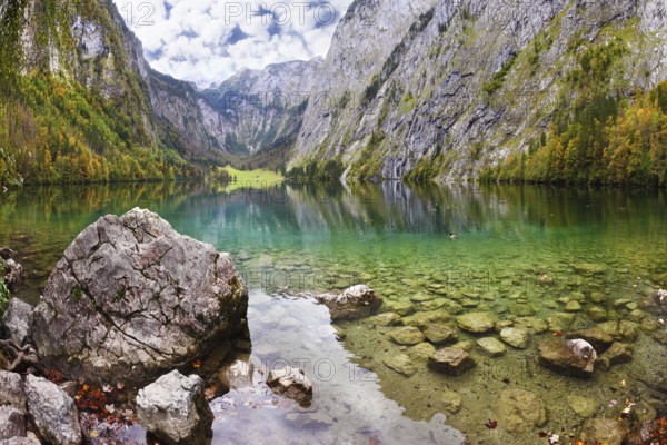 Magic reflection in German lake Koenigssee. Cloudy day on the lake. Clouds and mountains reflected in the emerald surface of the water