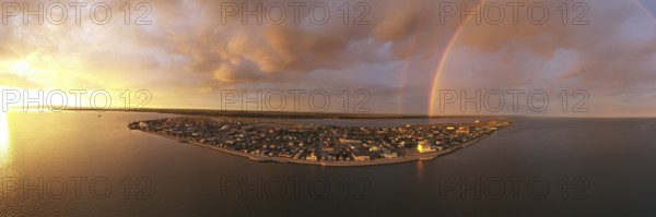 Rain falls as sun shines in the middle of the night at Kotzebue Alaska creating a beautiful contrast between the sunrise and storm