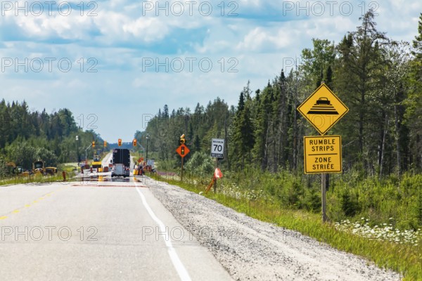 Temporary condition road warning signs on the roadside before road work zone, rumble strips on a bilingual yellow sign, Canadian rural roads