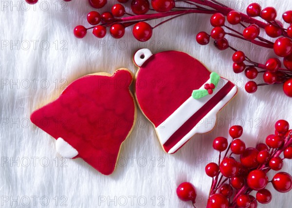Christmas cookies Xmas red bell shape on white fur background