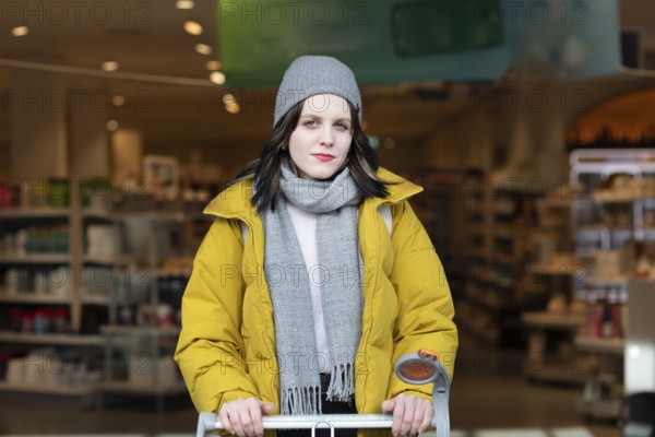 Woman in winter clothes shopping with a shopping trolley on foot, mobility, environmentally friendly