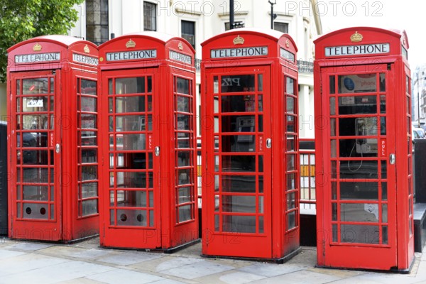 Europe, Several red telephone boxes on a city street, London, London region, England, United Kingdom, Europe