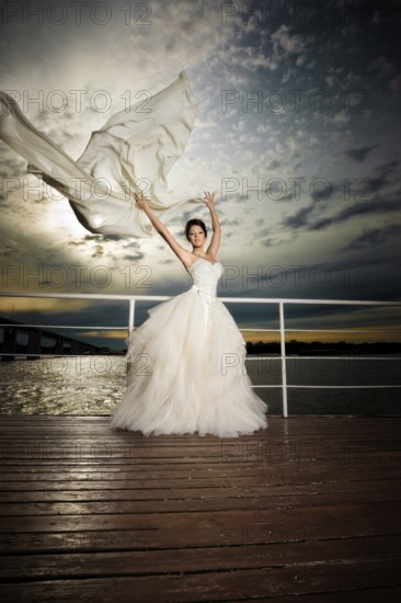 Pretty lady in a wedding dress on deck