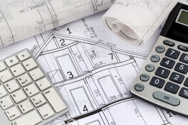 An architect's construction plan with a calculator. Symbolic photo for financing and planning a new house. Austria