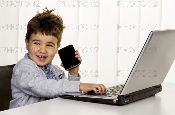 Little boy at the laptop, symbol for internet, e-commerce, consumer behaviour