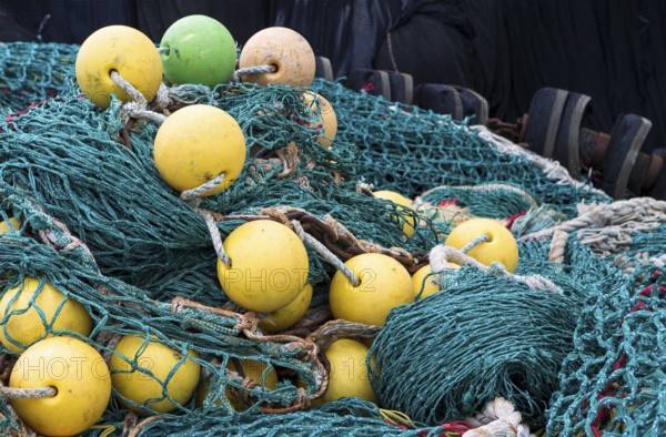The photo shows a pile of fishing nets with floats
