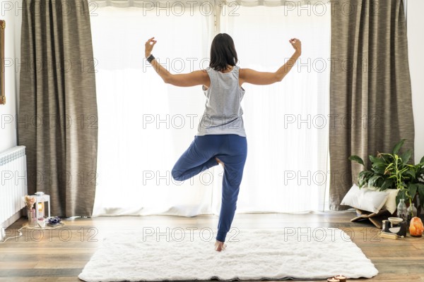 Rear view of a dedicated woman engaging in yoga and performing mudras gracefully