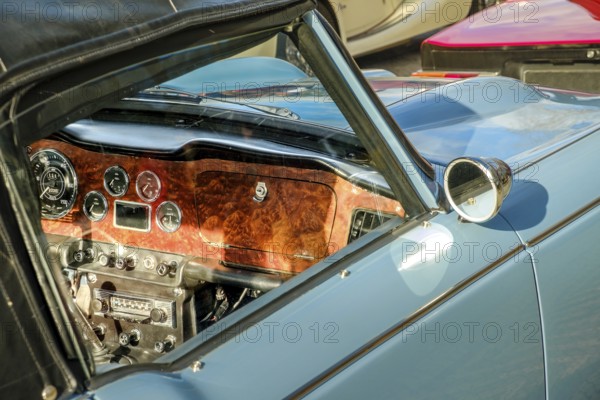 Lisbon, Portugal, Jan 20, 2024: Car design details, interior of vintage car in leather and wood, authentic front panel, glove box, meters and radio, Europe