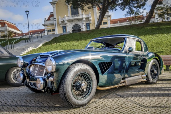 Lisbon, Portugal, Jan 20, 2024: Vintage green Austin Healey 3000 sports car on cobblestone near green park. 2-door 2-seater roadster with hardtop by Austin-Healey BMC, Europe