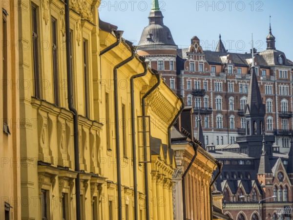 View of a row of historic buildings with yellow facades and roofs, detailed architecture in the background, stockholm, baltic sea, sweden, scandinavia