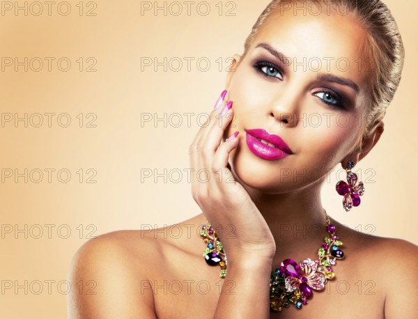 Beautiful woman with dark makeup and pink lipstick posing on beige background wearing flower spring and summer jewellry necklace, Toronto, Canada, North America