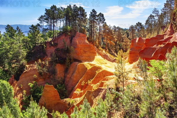 France, Provence. The village of Roussillon is surrounded by picturesque ocher cliffs. Now the rocks have grown into dense forests. Bizarre ocher rocks, Europe