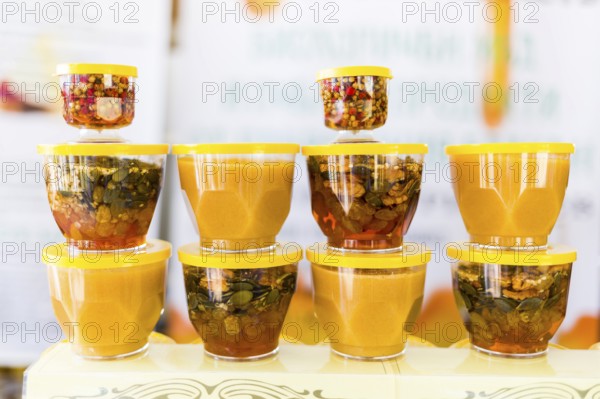 Honey with dried fruits and dried nuts - walnuts, hazelnuts, peanuts, almonds, cashews, plums, cherries, apples, figs and dates
