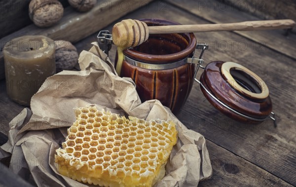 Honeycomb wrapped in grey paper on the background of the jars